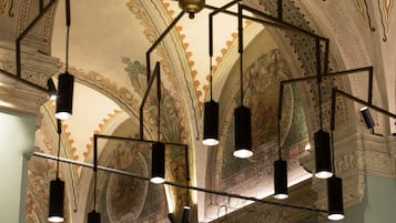 Un plafond orné de motifs complexes et agrémenté de luminaires suspendus.