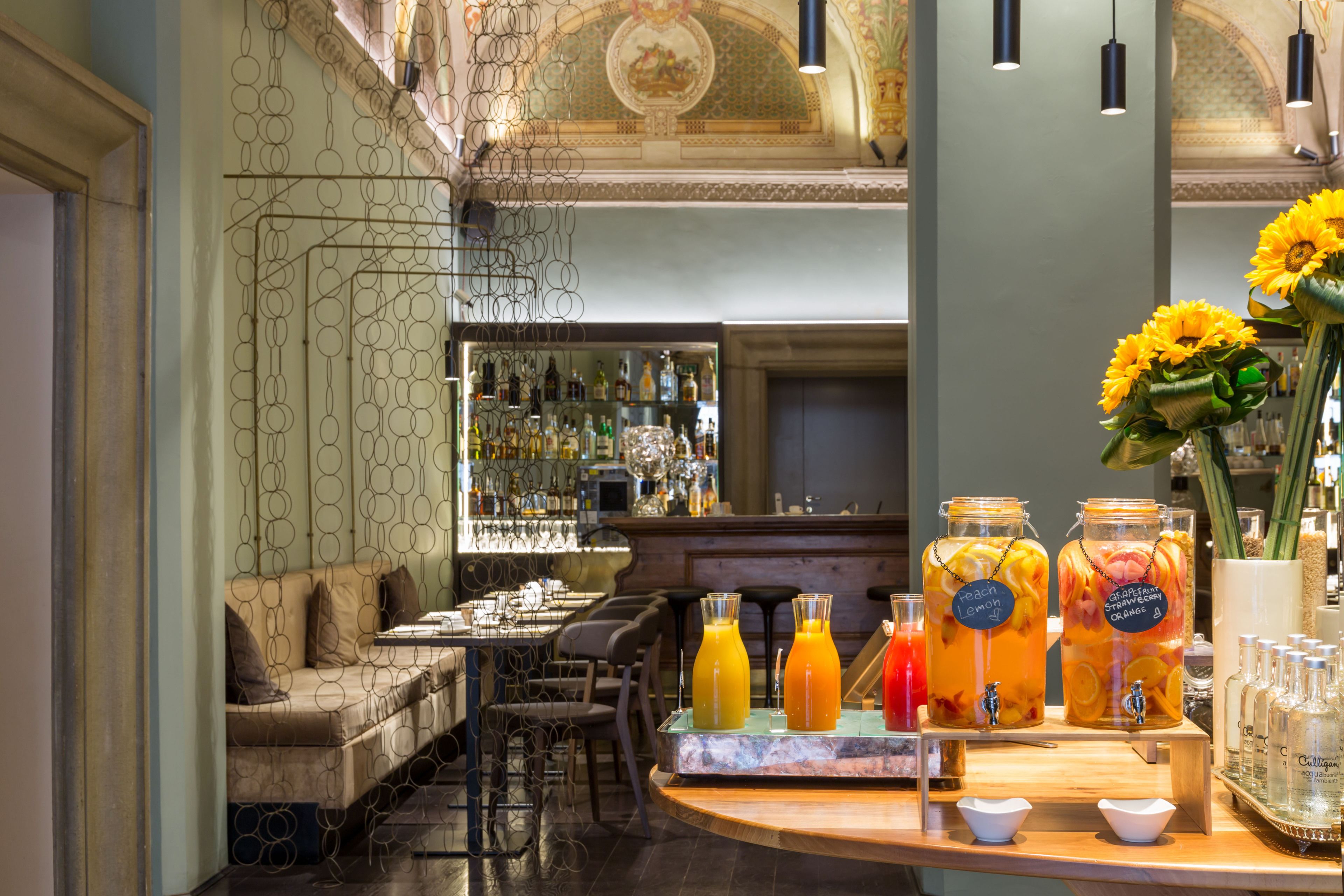 A bar area with a seating arrangement, a counter with drinks, and a decorative ceiling.