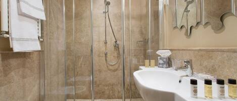 Une salle de bain avec une douche à parois de verre, un lavabo blanc et un miroir.