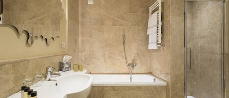 Un baño moderno con lavamanos doble, bañera y ducha con cerramiento de vidrio.