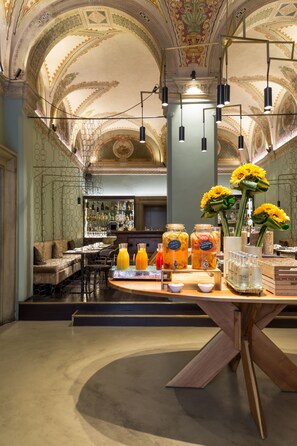 A bar area with a bar counter, seating, and a decorative ceiling.