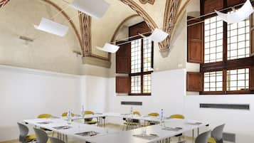 A conference room with a long table, chairs, and ceiling lights.