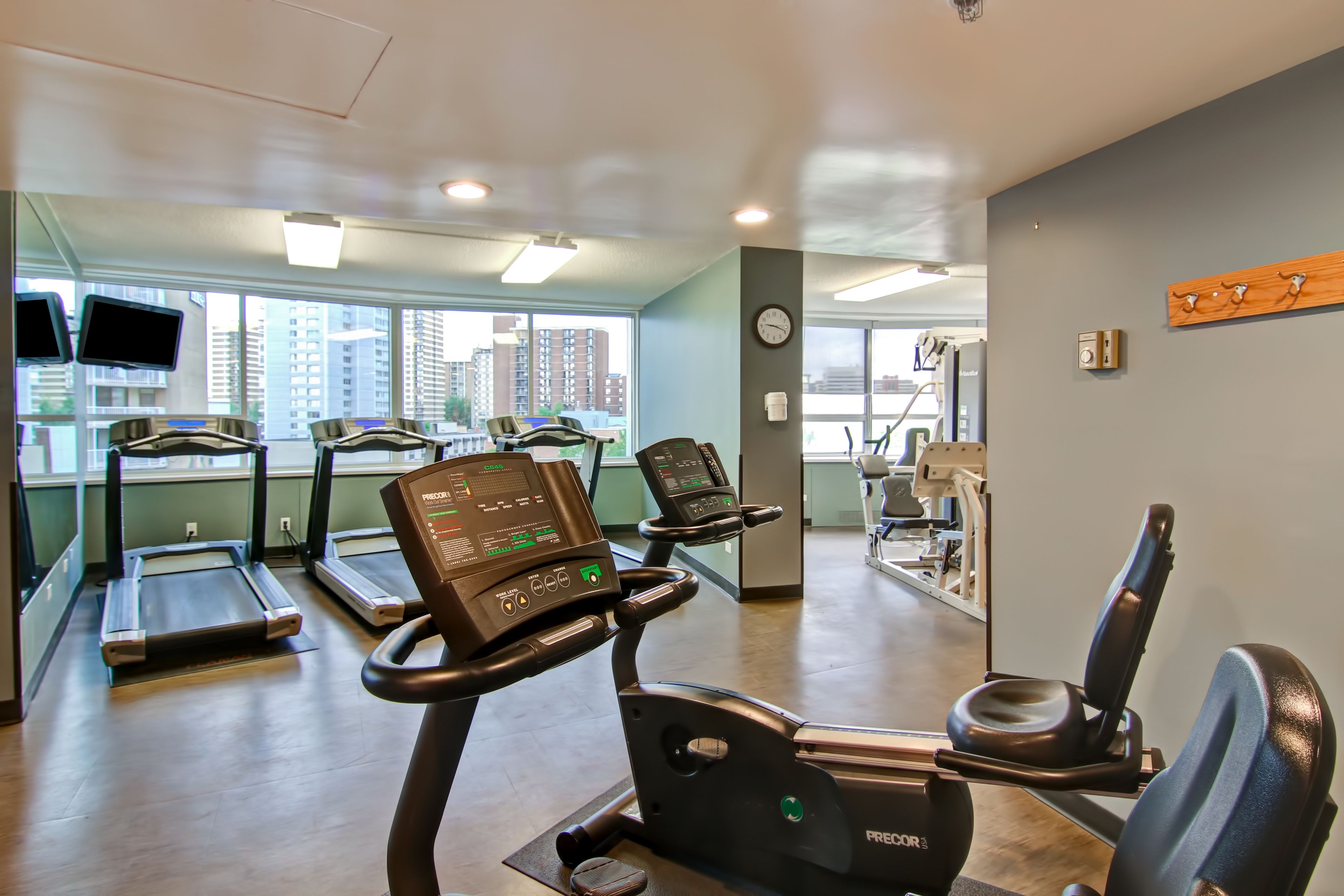 A gym with treadmills, exercise bikes, and a rowing machine.