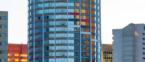 Un edificio alto e moderno con una sommità cilindrica e numerose finestre.