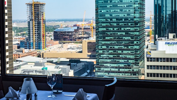 A hotel room with a view of a cityscape, including a construction site and high-rise buildings. - Chateau Lacombe Hotel (Edmonton)