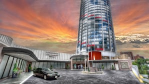 A modern hotel with a curved facade, a central entrance, and a parking area. - Chateau Lacombe Hotel (Edmonton)