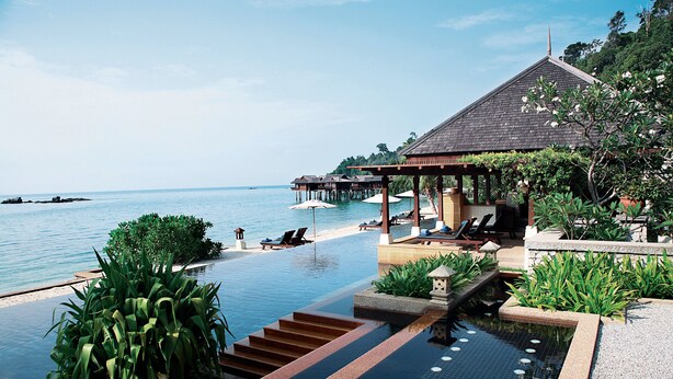 An infinity pool with a view of the sea, a covered seating area, and lush greenery. - Pangkor Laut Resort  (Pangkor Laut)