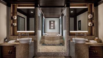 A modern bathroom with two sinks, a large mirror, and a central staircase leading to a shower area.