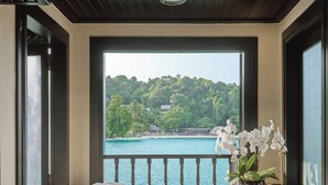 A bathroom with a view of a lake and forest, a marble sink, and a potted orchid. - Pangkor Laut Resort  (Pangkor Laut)