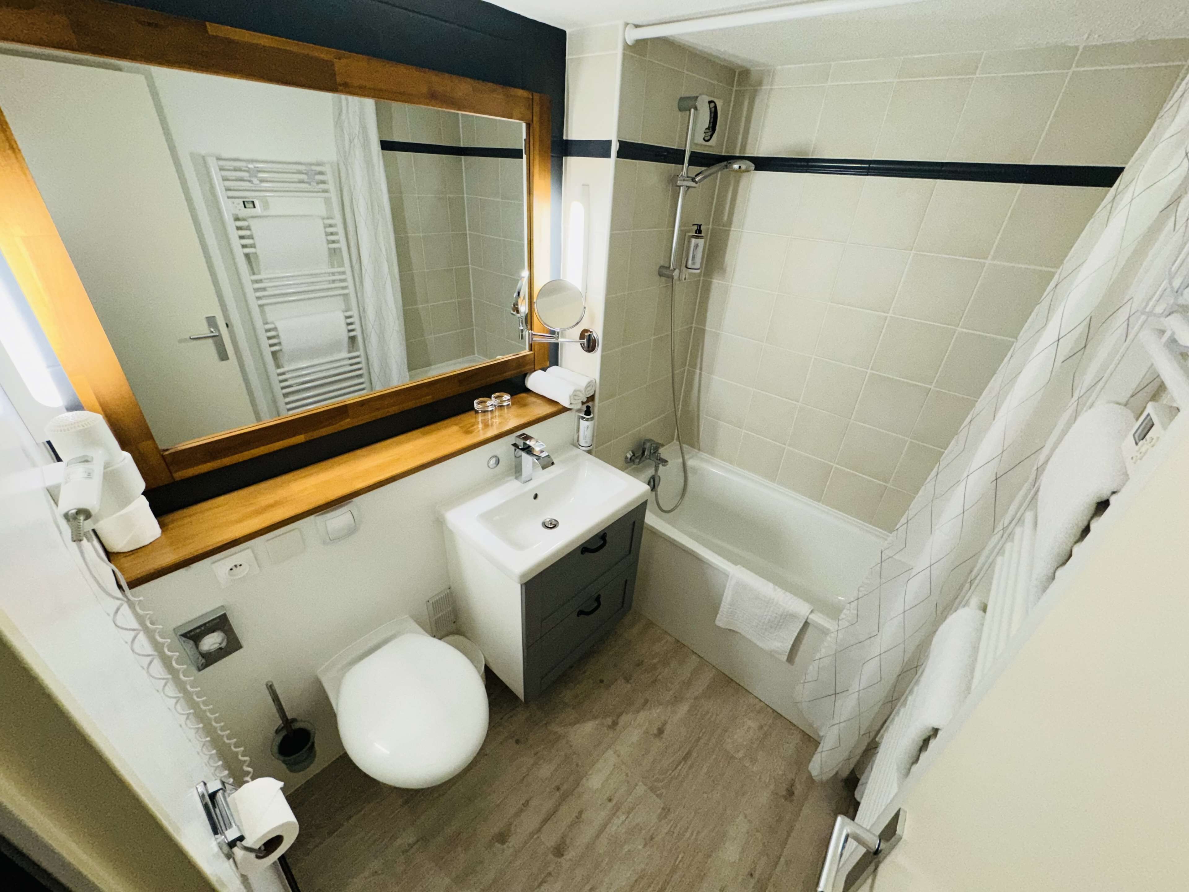 A bathroom with a sink, toilet, and shower.