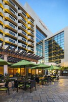 Exterior de un hotel con asientos al aire libre y un diseño arquitectónico moderno.