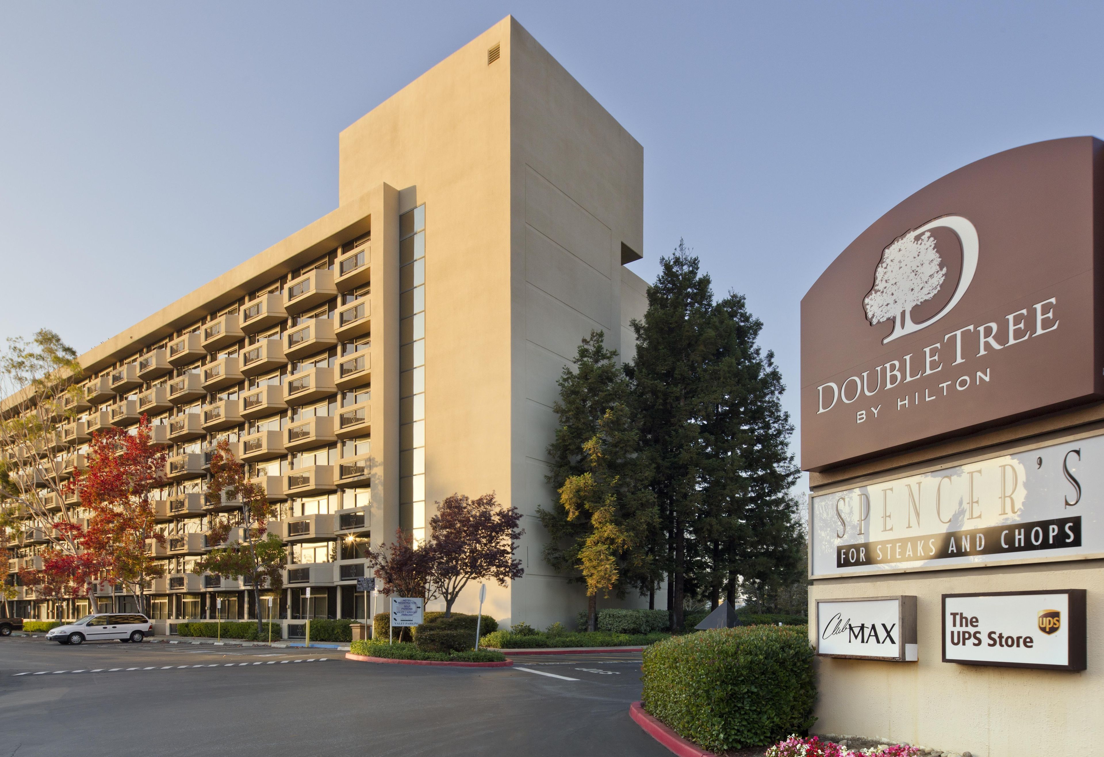 Un hotel con un cartel que anuncia 'DoubleTree by Hilton' y 'Spencer's para carnes y chuletas'.