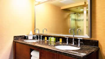 Un baño con dos lavamanos, un espejo y un perchero para toallas.