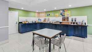 A modern kitchen with a central island, blue cabinets, and a white countertop.