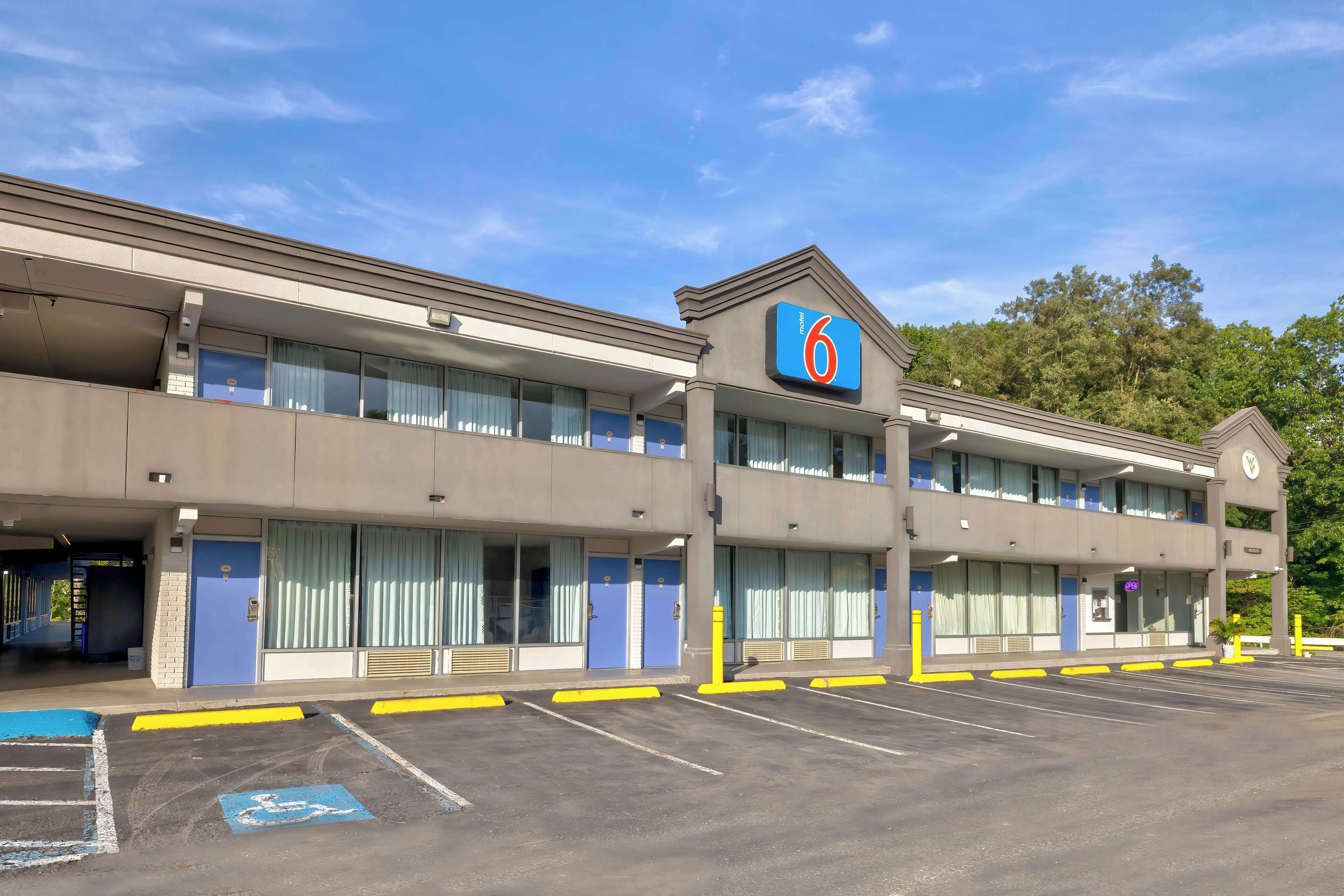 A motel with a '6' sign, multiple rooms, and a parking lot.