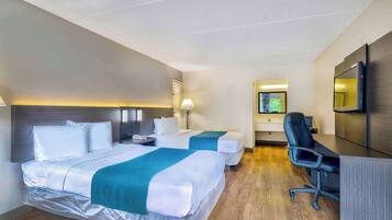 A hotel room with two beds, a desk, a chair, a TV, and a mirror.