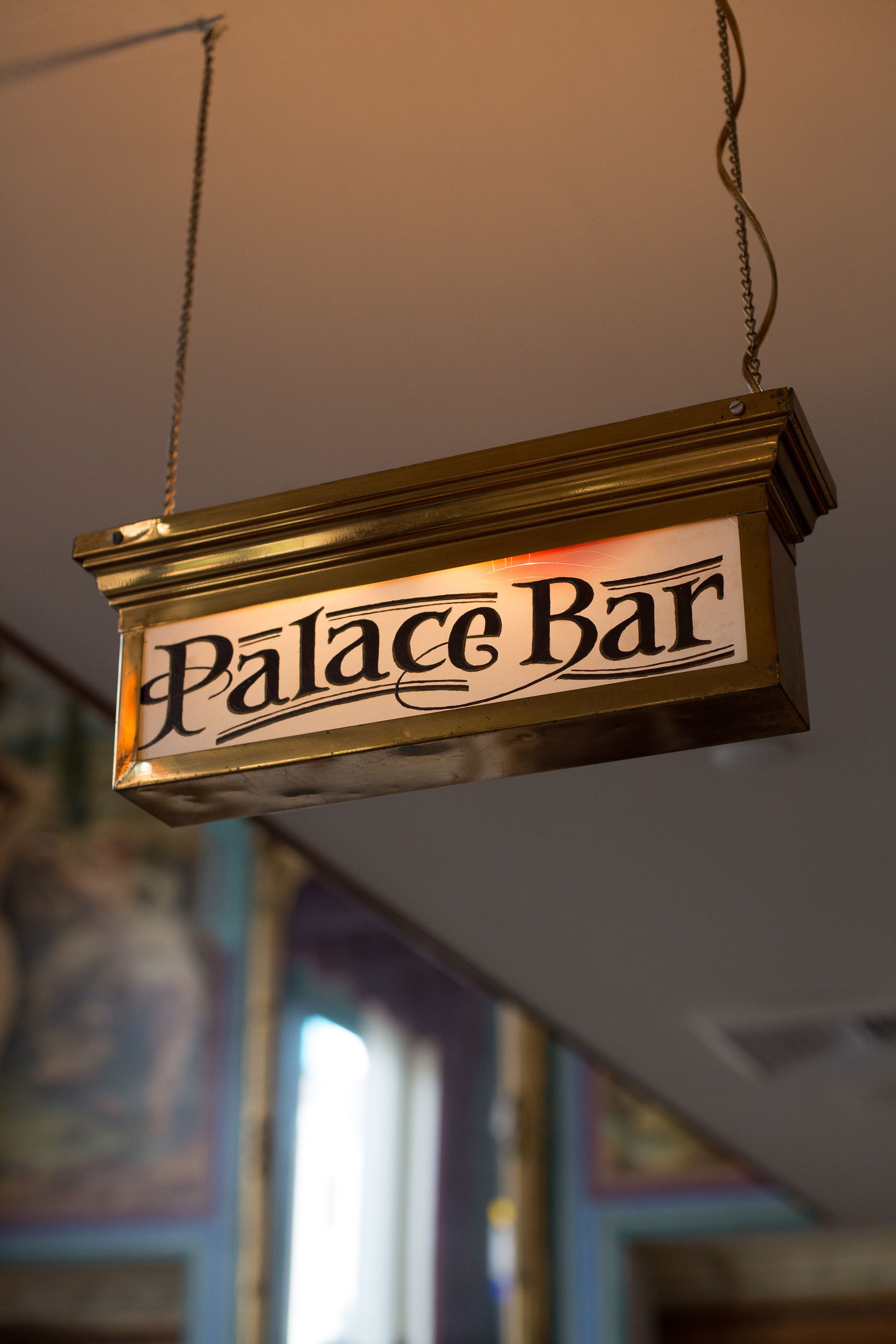 A hanging sign with the text "Palace Bar".