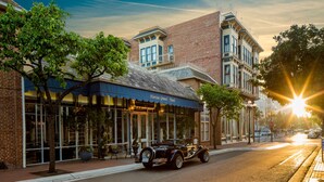 A vintage car parked in front of a building with a sign that reads "Horton Grand Hotel."