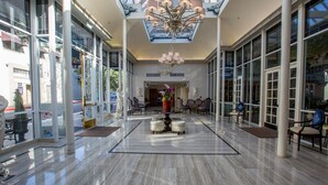 A spacious lobby with a high ceiling, large windows, and a central chandelier.