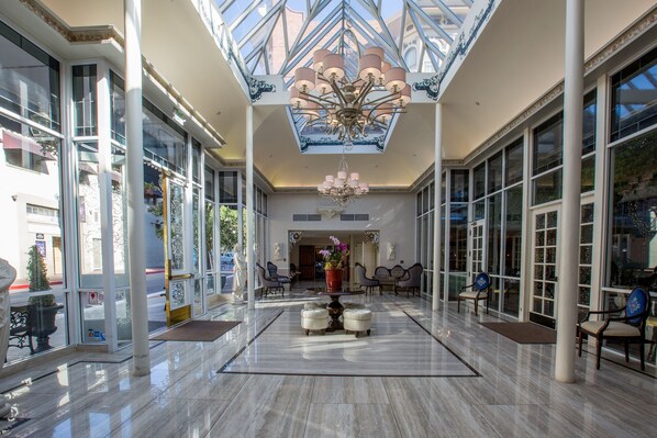 A spacious lobby with a high ceiling, large windows, and a central chandelier. - The Horton Grand, Downtown/Gaslamp Quarter (San Diego)