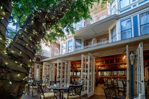 A restaurant with outdoor seating, brick walls, and decorative lighting. - The Horton Grand, Downtown/Gaslamp Quarter (San Diego)
