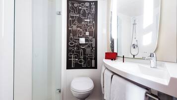 Ein modernes Badezimmer mit einer Duschkabine aus Glas, einer weißen Toilette, einem weißen Waschbecken mit Spiegel und einer schwarz-weißen abstrakten Wanddekoration.