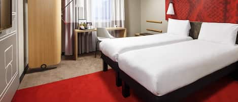Una habitación de hotel con una cama grande, un escritorio, una silla, un televisor y un armario.