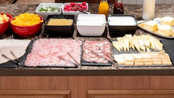 A buffet with various food items and condiments.