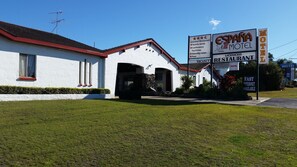 Un edificio blanco con techo rojo, identificado como Motel EspaNA y con restaurante autorizado.