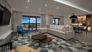 Un salon moderne avec un canapé d’angle, un fauteuil bleu et un coin repas comprenant une table et des chaises.