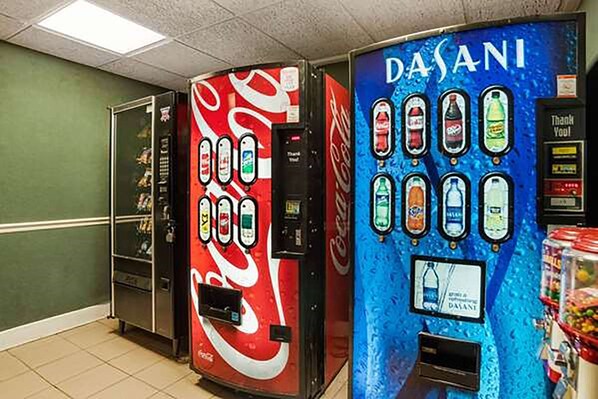 Zona de máquinas expendedoras con dispensadores de Coca-Cola y agua Dasani.