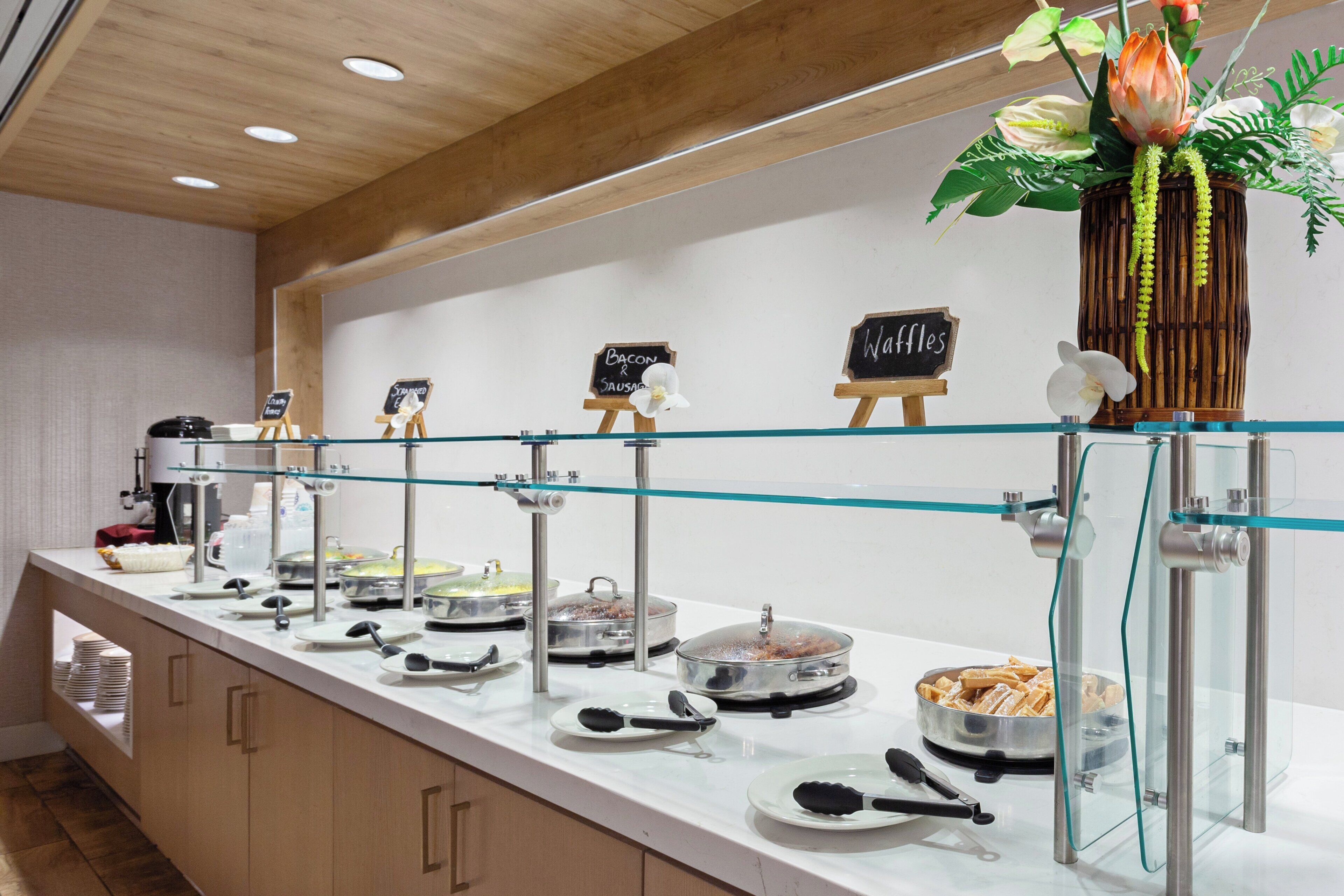 A buffet setup with various food items and serving utensils.
