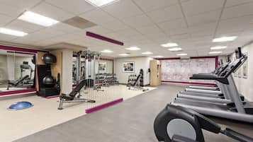 Ein Fitnessstudio mit Laufbändern, Kraftgeräten und Trainingsbällen.