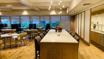 A conference room with a long table, chairs, and a fruit centerpiece.