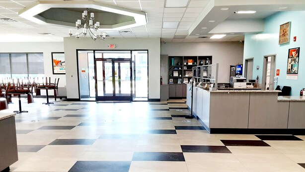 A spacious lobby with a checkered floor, a reception desk, and a chandelier. - Howard Johnson by Wyndham Florence (Florence)