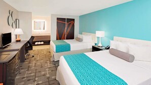 A hotel room with two beds, a desk with a computer, a chair, and a bathroom with a mirror. - Howard Johnson by Wyndham Florence (Florence)