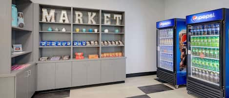 A vending area with snack and drink options, including Pepsi refrigerators and a 'MARKET' display with various products.
