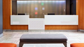 A reception area with a modern design, featuring a reception desk, seating area, and a large window with vertical blinds. - Best Western Plus Meridian Inn & Suites, Anaheim-Orange (Orange)