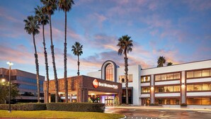 A hotel with a modern design, featuring a prominent archway entrance, multiple floors, and palm trees in the foreground. - Best Western Plus Meridian Inn & Suites, Anaheim-Orange (Orange)