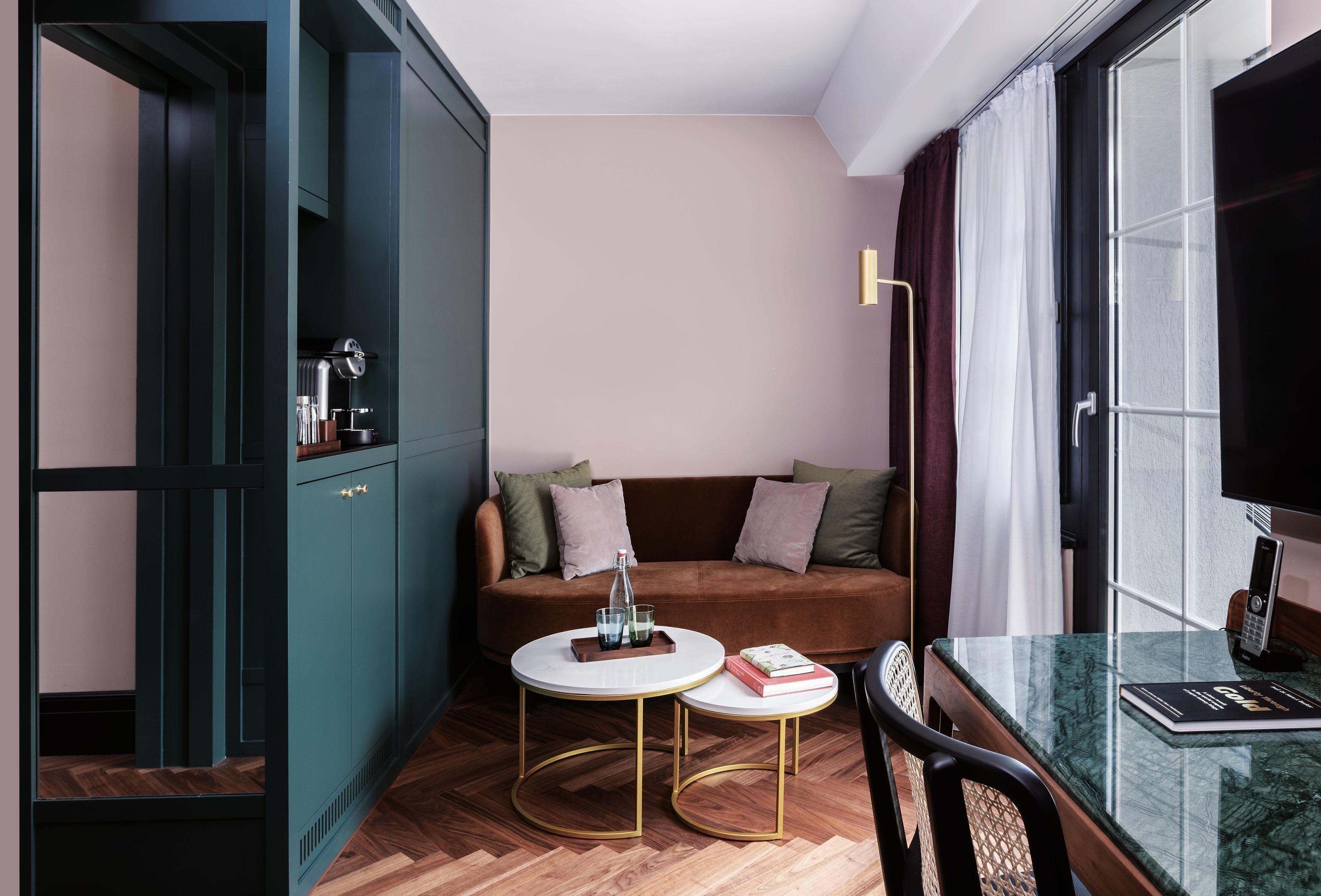 A modern living room with a sofa, two round tables, a television, and a cabinet.