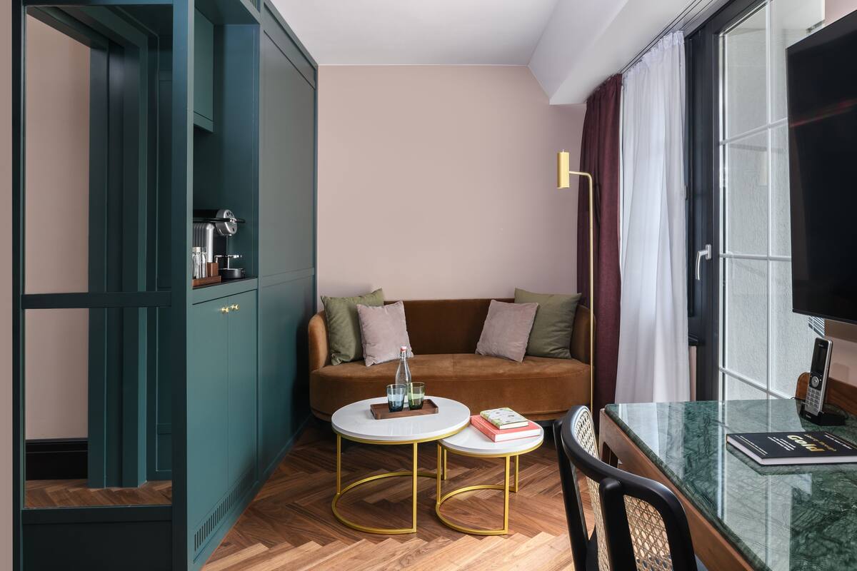 Un salon moderne avec un canapé marron, des meubles turquoise, une table basse ronde et une table à manger en verre.