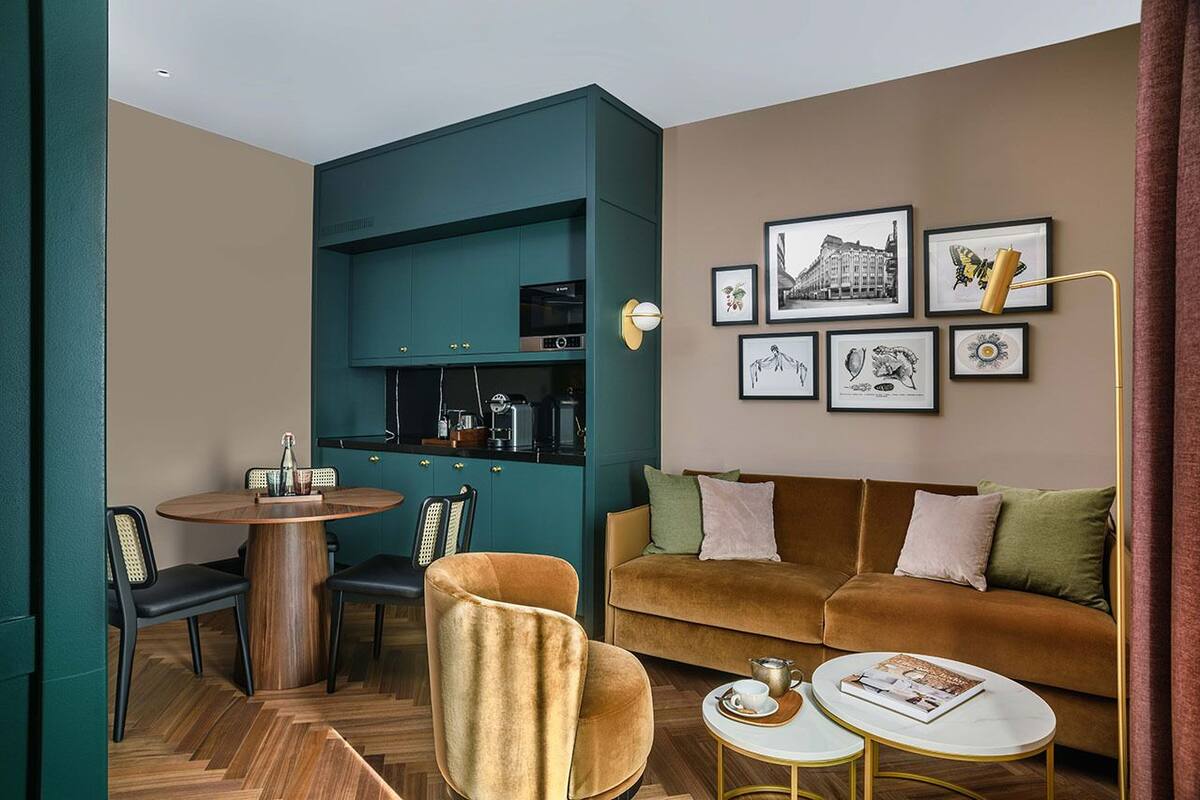 Un salon moderne avec un mur d’accent de couleur turquoise, un canapé marron, une table ronde en bois et une table basse.