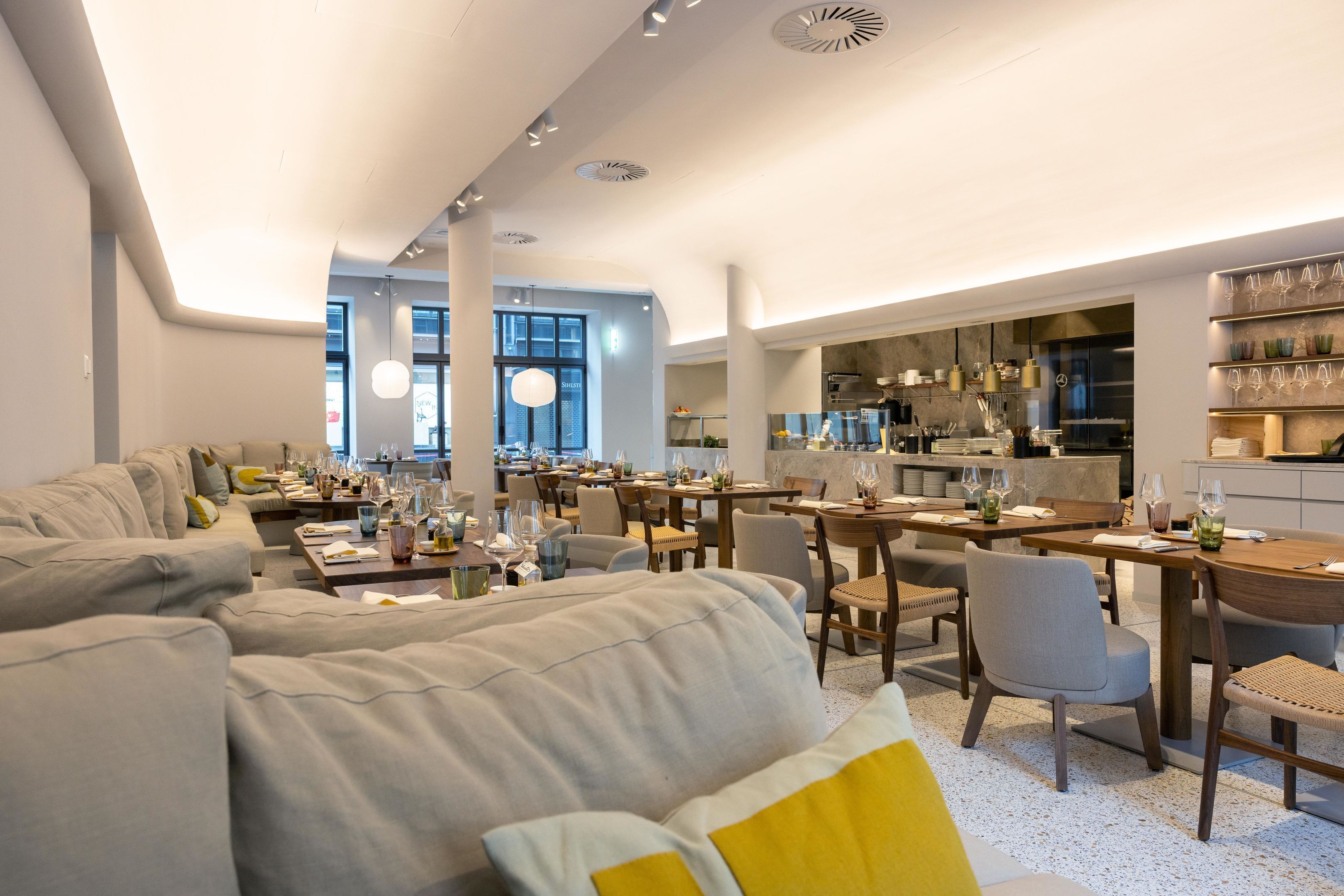 Un interior moderno con comedor, sofás y cocina.