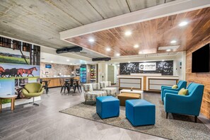 A modern reception area with a wooden ceiling, a reception desk, seating arrangements, and a mural of horses.