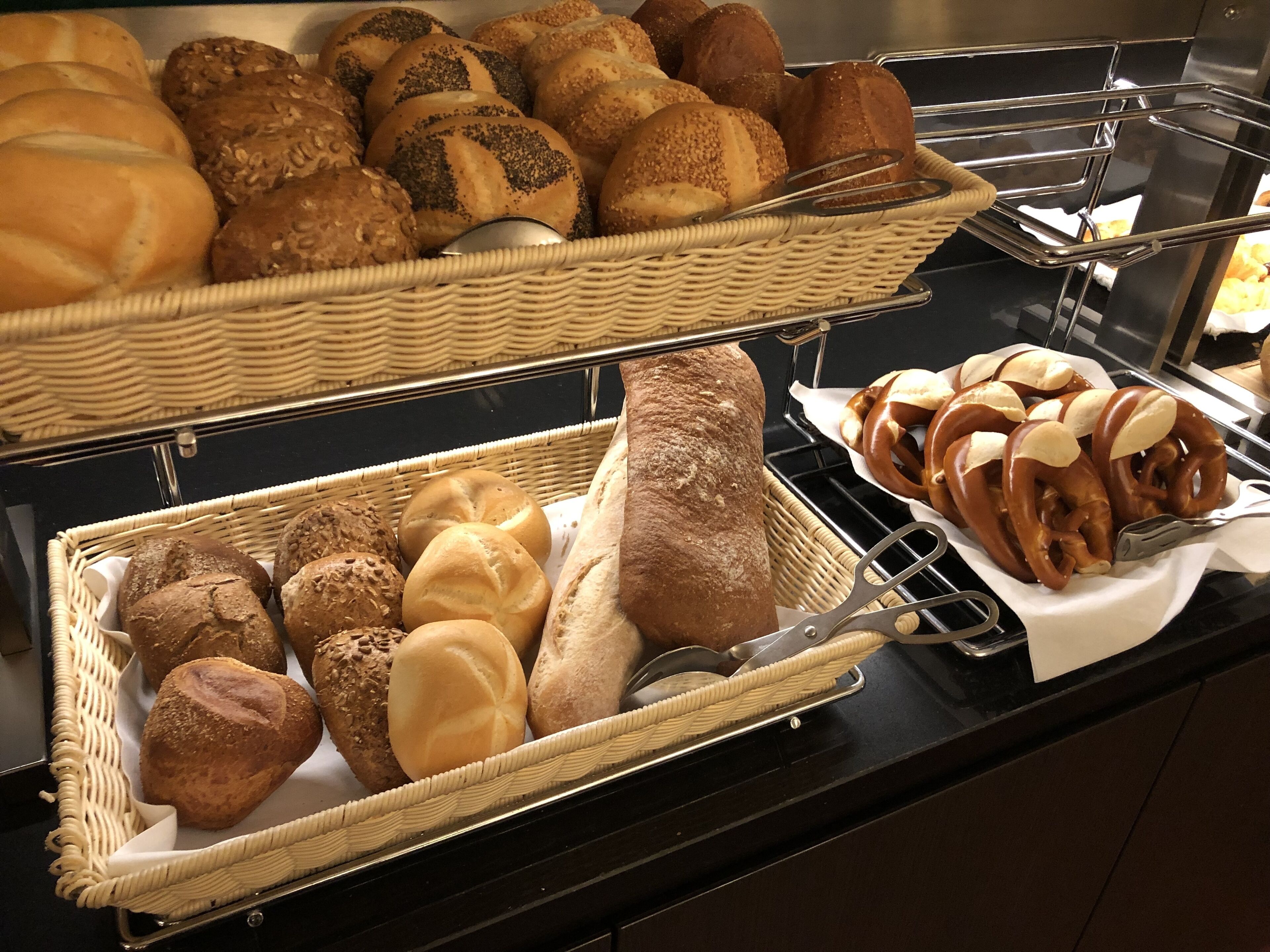 A buffet with various breads and rolls.