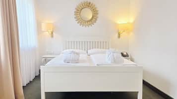 Ropa de cama hipoalergénica y caja de seguridad en la habitación