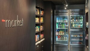 A section of a hotel with a wall labeled "the market" and two refrigerated display cases filled with beverages and snacks. - Courtyard by Marriott Annapolis (Annapolis)