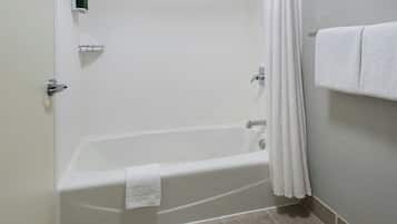 Um banheiro com banheira, porta-toalhas e cortina de chuveiro.