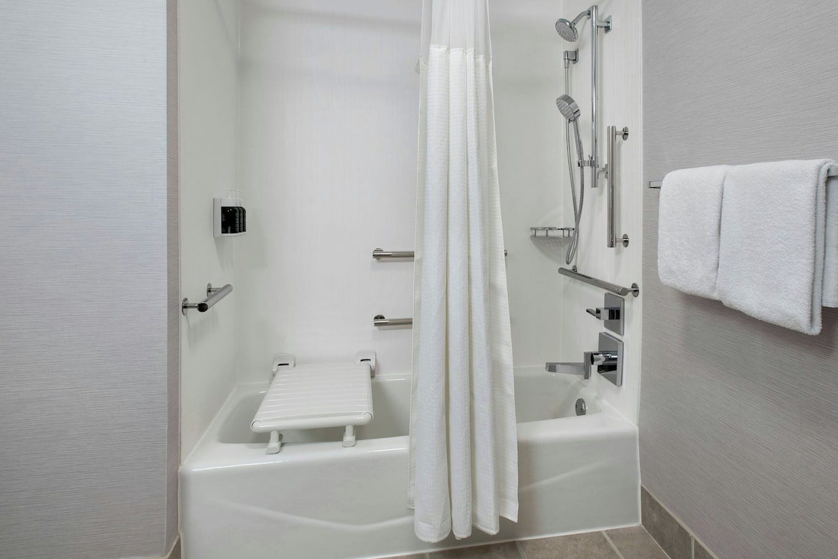 Un baño moderno con bañera, ducha y toallero.