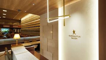 Un interior moderno con un mostrador de recepción, un área de estar y una pared con el texto "BARGANTUA SALON".